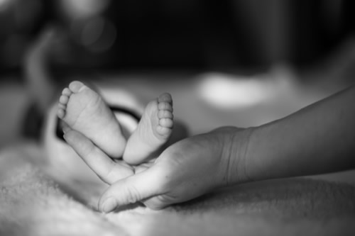 mother cradling baby feet