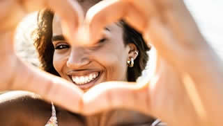 Woman making a heart with her hands.